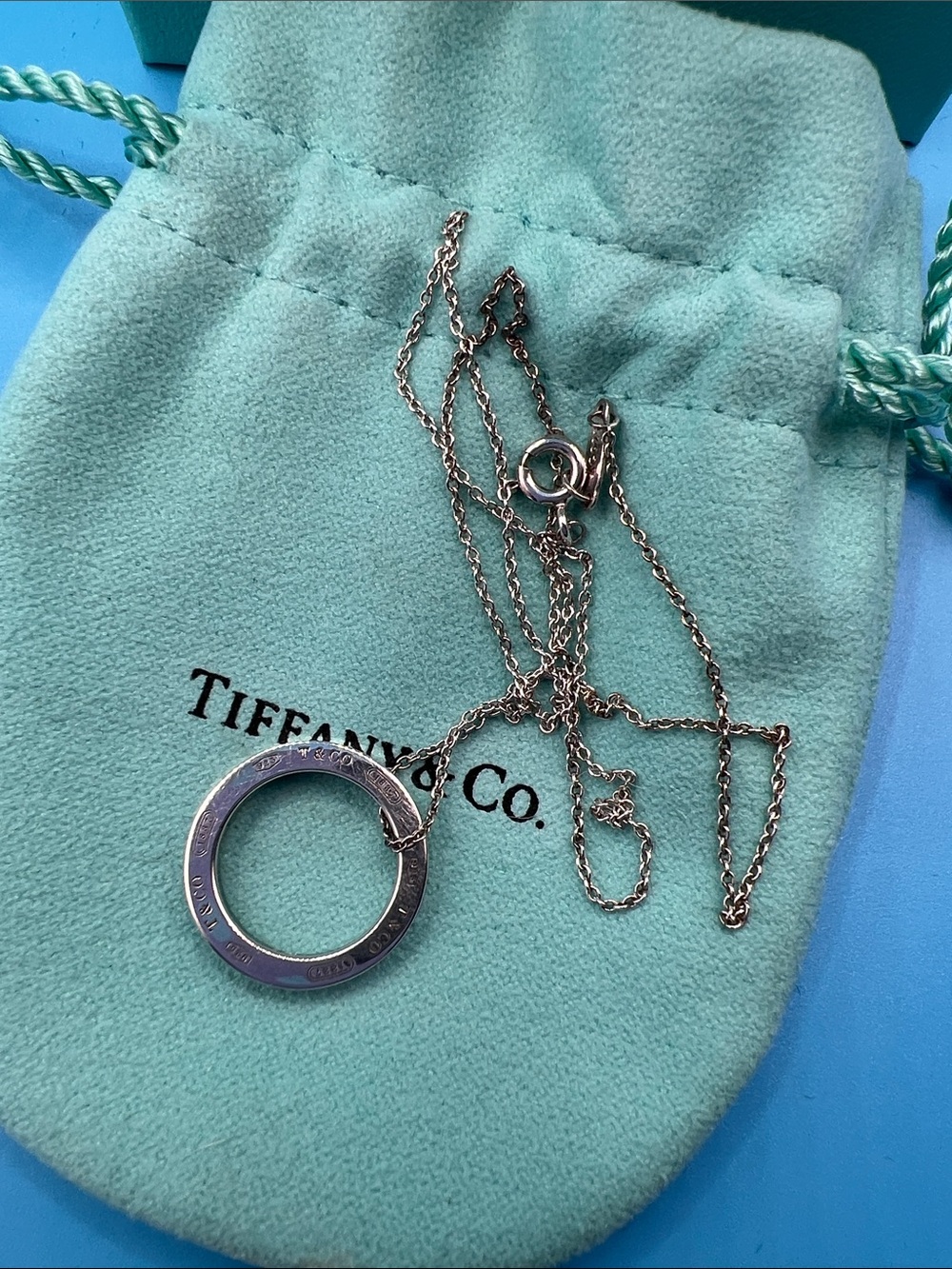 Tiffany & Co. Silver Circle Pendant Necklace on Blue-Green Pouch and box